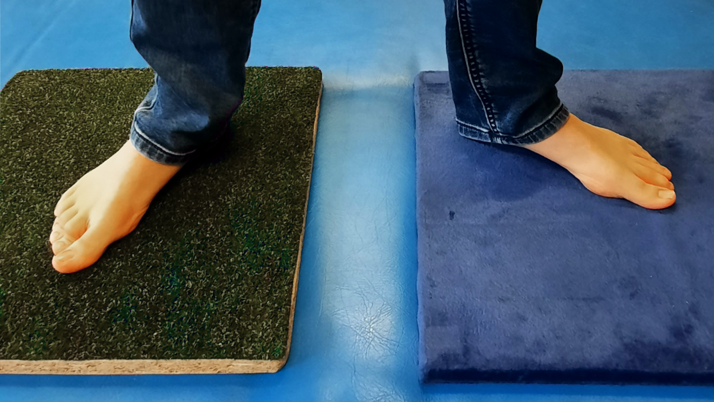 Füße stehen auf Platten mit verschiedenen Oberflächen