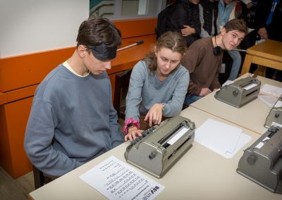 Schülerin erklärt Teilnehmer den Perkins Brailler